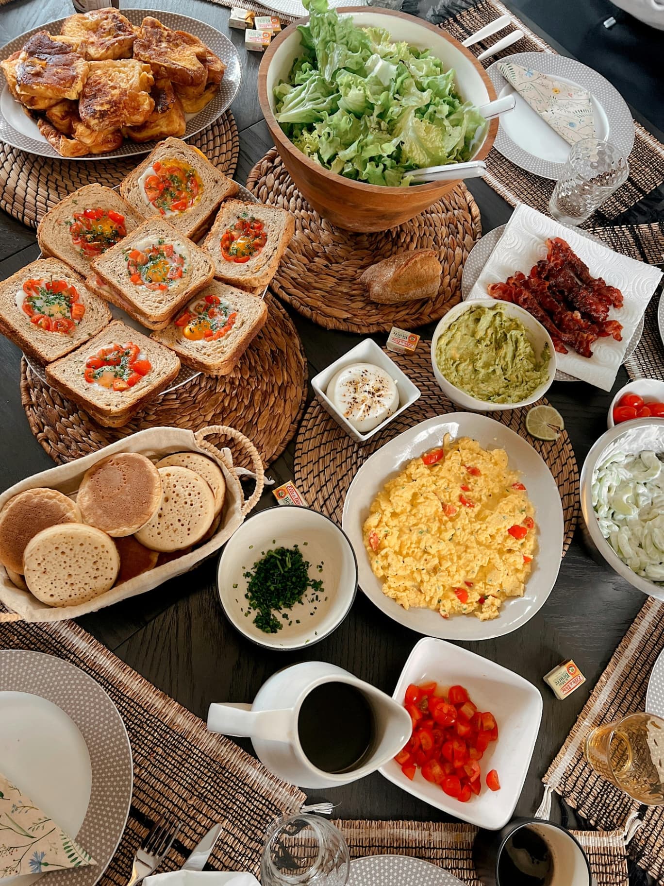 Mesa de brunch compartilhada com ovos, panquecas, pães e café